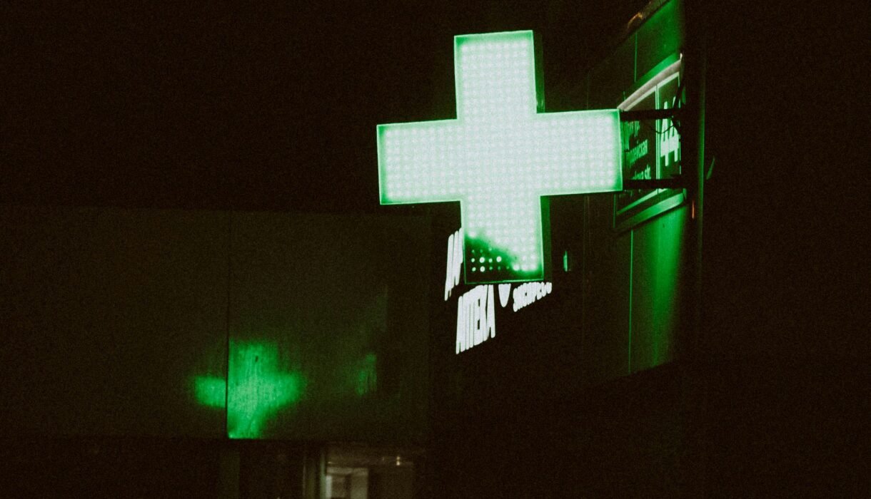 How to thrive on night shifts in a dim hospital with neon green plus sign Hospital at night with neon green plus sign glowing in dark