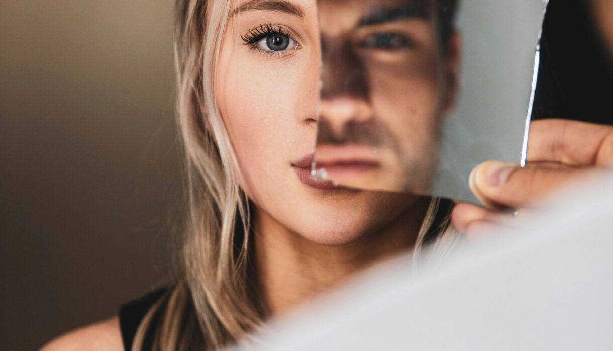 Signs of a covert narcissist in relationships symbolized by a broken mirror distorting identity.